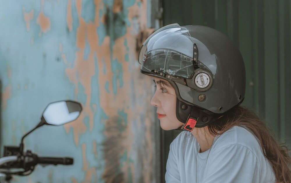ヘルメットをかぶって外を見つめる女性